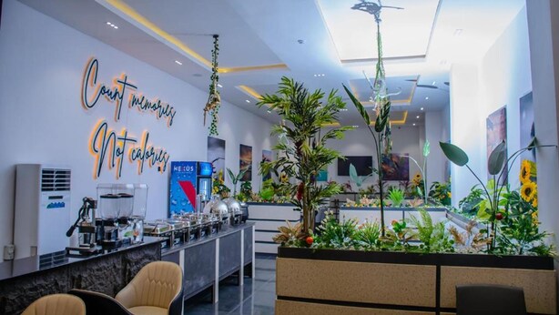 A modern hotel lobby with a reception desk, seating area, and a large indoor garden. - G Pinnacle Signature Hotel (Ilorin)