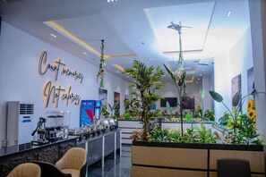 A modern hotel lobby with a reception desk, seating area, and a large indoor garden. - G Pinnacle Signature Hotel (Ilorin)