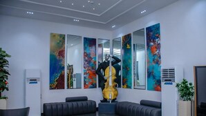A modern lobby with a large abstract painting, a caviar sculpture, and a seating area. - G Pinnacle Signature Hotel (Ilorin)