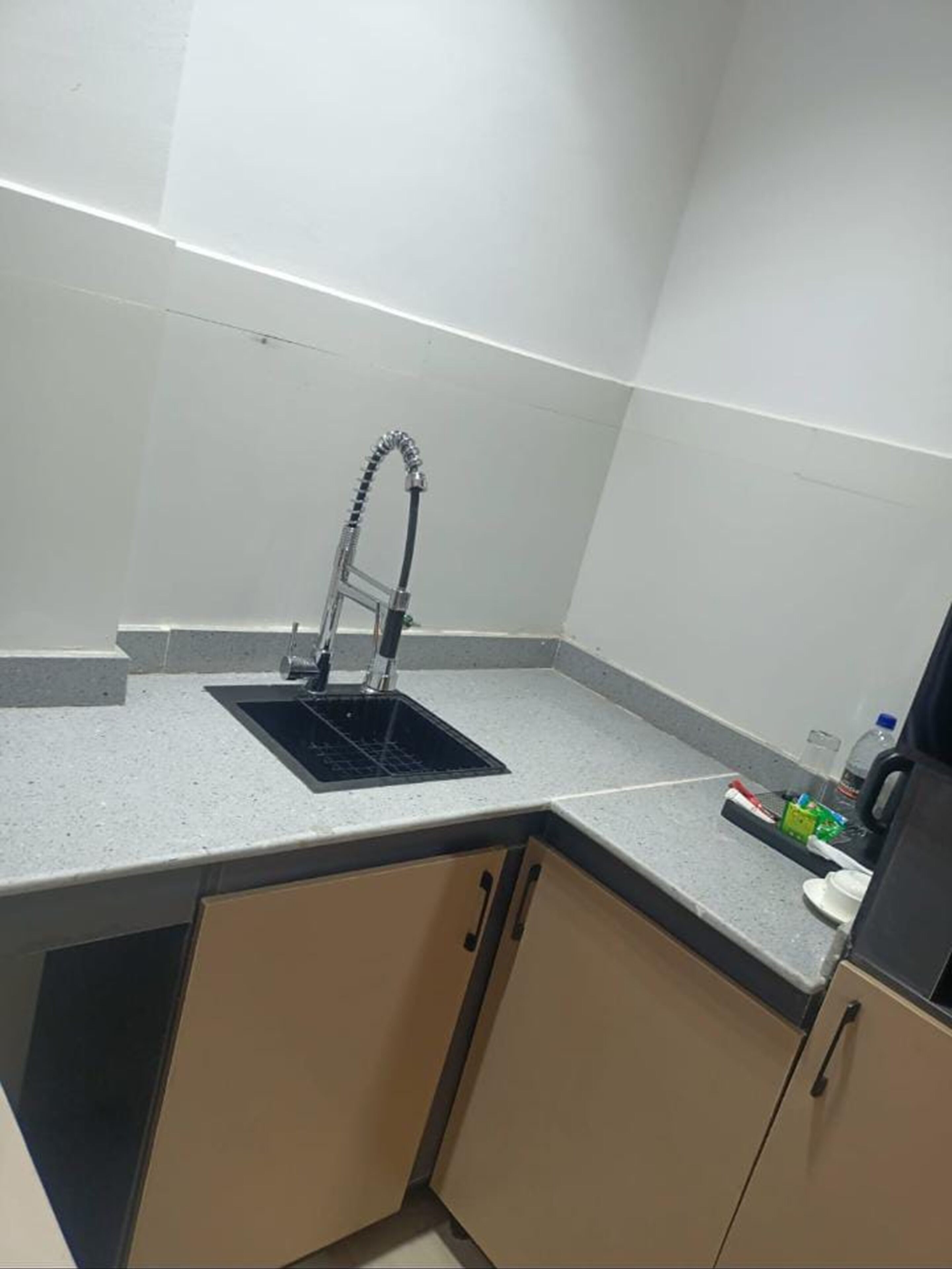 A small kitchenette with a sink, a faucet, and a countertop.