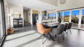 A modern kitchen with a dining area, large windows, and a view of the outdoors. - Limestone Views: Discover this farmhouse set in a bend of the Tambo River (Swan Reach)