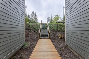 A wooden pathway leading to a staircase between two buildings. - Pet Friendly 1br/1ba 18 Powderidge (Snowshoe)