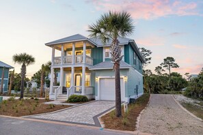 A two-story house with a porch, a garage, and a driveway.