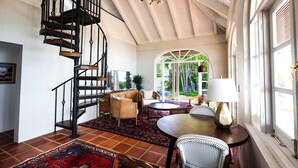 A spacious room with a spiral staircase, a dining area with a table and chairs, and a view through a large arched window. - Big Hill - a luxurious haven that will not disappoint, View Sunrise, Dock (Elbow Cay)