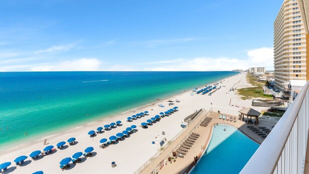 A beach resort with a pool, sun loungers, and umbrellas. - Beachfront resort condo w/ beach access (Panama City Beach)