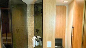 A modern bathroom with a glass shower enclosure, a toilet, and a trash bin. - Setai Yacht Luxxor - By Almare Flats (João Pessoa)