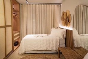 Un dormitorio con cama, mesitas de noche, armario y espejo.
