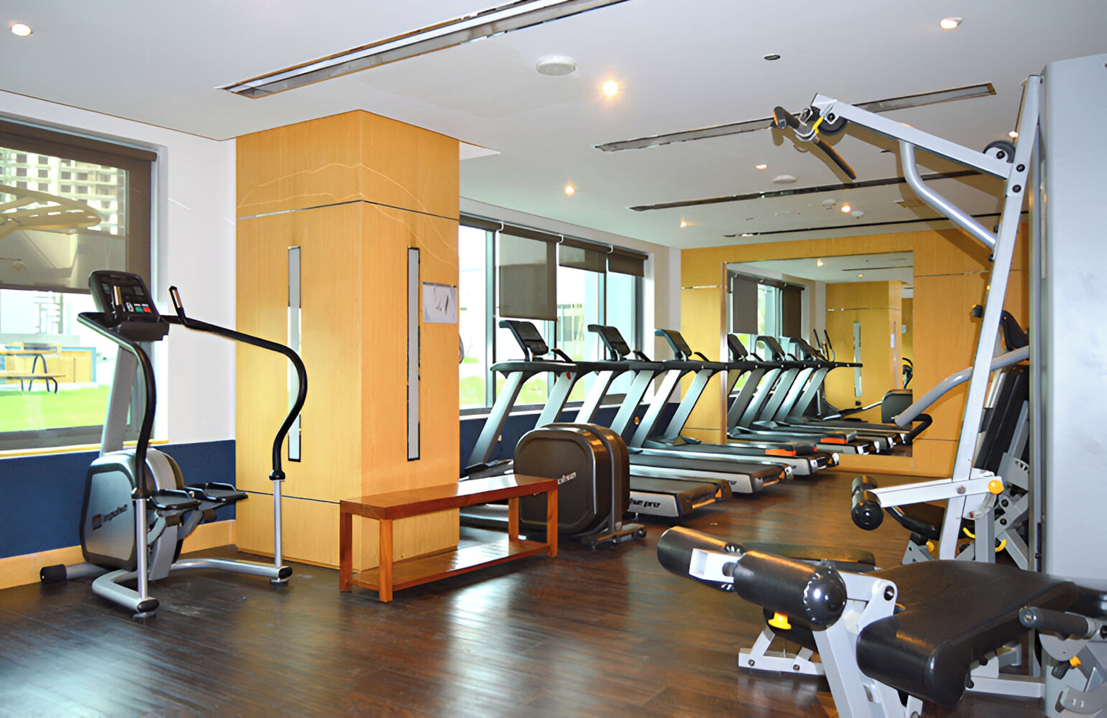 A gym with treadmills, elliptical machines, and weight equipment.