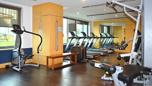 A gym with treadmills, elliptical machines, and weight equipment. - Waves - Executive Bay Studio: Canal View/Modern Amenities  (Dubai)