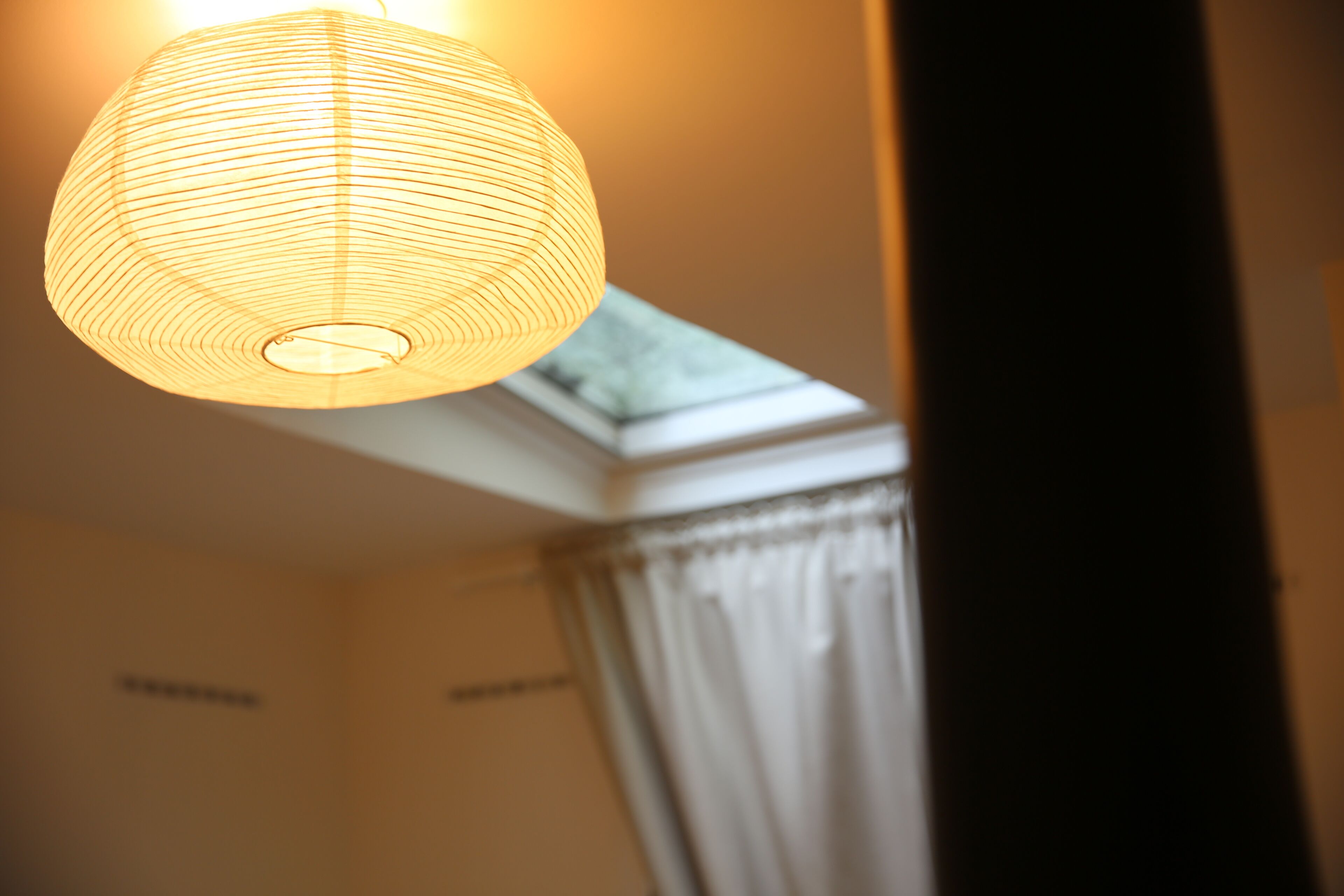 Ein Zimmer mit Deckenleuchte und Dachfenster.
