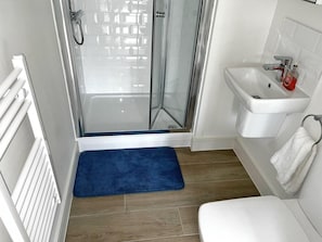 Un baño con ducha, lavamanos e inodoro.