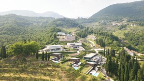 Et moderne resort med flere bygninger, en swimmingpool og frodigt grønt landskab.