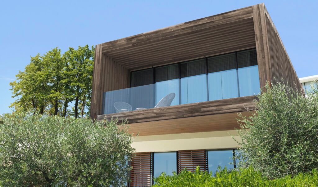 Un immeuble moderne à deux étages, doté de grandes fenêtres et d’un balcon.