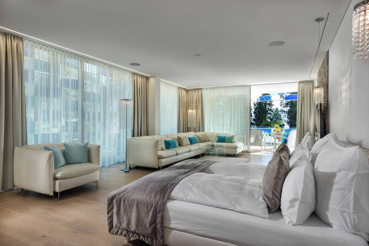 Une chambre spacieuse avec un grand lit, un canapé et une table basse en verre.