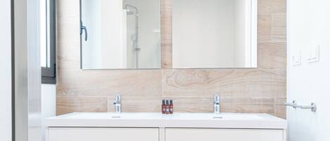A modern bathroom with a double vanity, wooden wall tiles, and a large mirror.