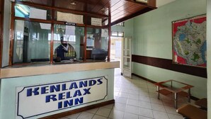 A reception desk with a sign reading "KENLANDS RELAX INN" and a map on the wall. - KENLANDS RELAX INN (Nakuru)