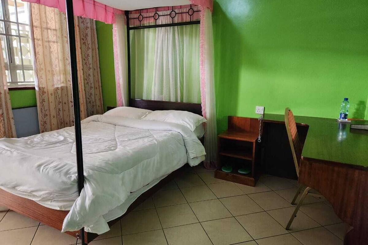 Una habitación con una cama, un escritorio y una silla.