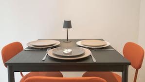 Taula de dinar amb quatre plats, coberts i una làmpada.
