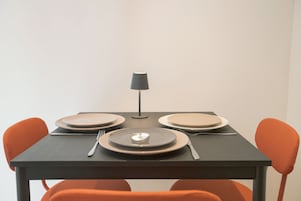 Una mesa de comedor con cuatro platos, cubiertos y una lámpara.