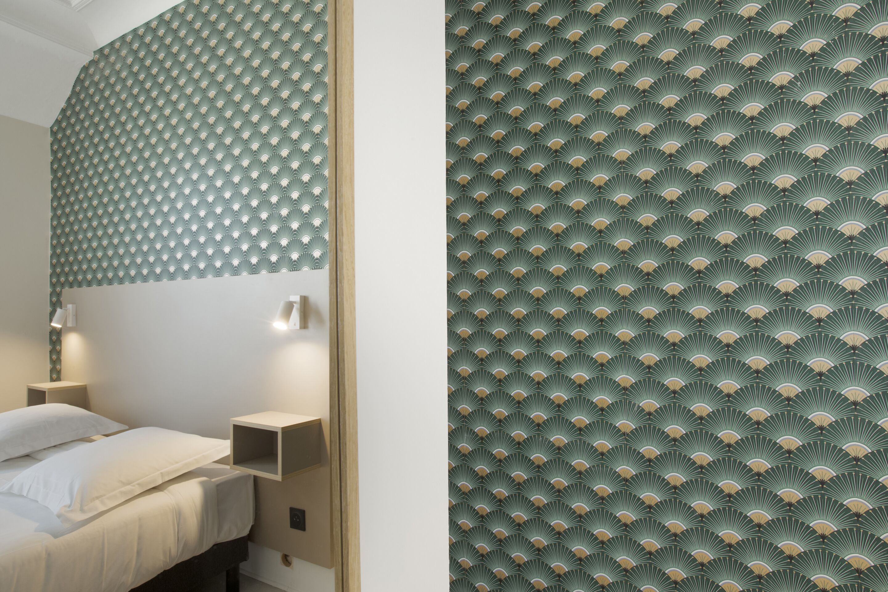 Un dormitorio con cama, mesitas de noche y una pared con diseño geométrico.