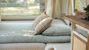 A bed with multiple pillows and a window with curtains. - Horizon - L'évasion Autonome (Cysoing)