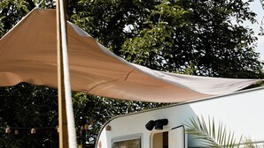 A mobile home with a deck, a canopy, and a window. - Horizon - L'évasion Autonome (Cysoing)