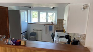 A kitchen with a wooden countertop, a window with a view, a radiator, and a sink. - Country house with large private courtyard. Pets welcome. (LANUEJOULS)