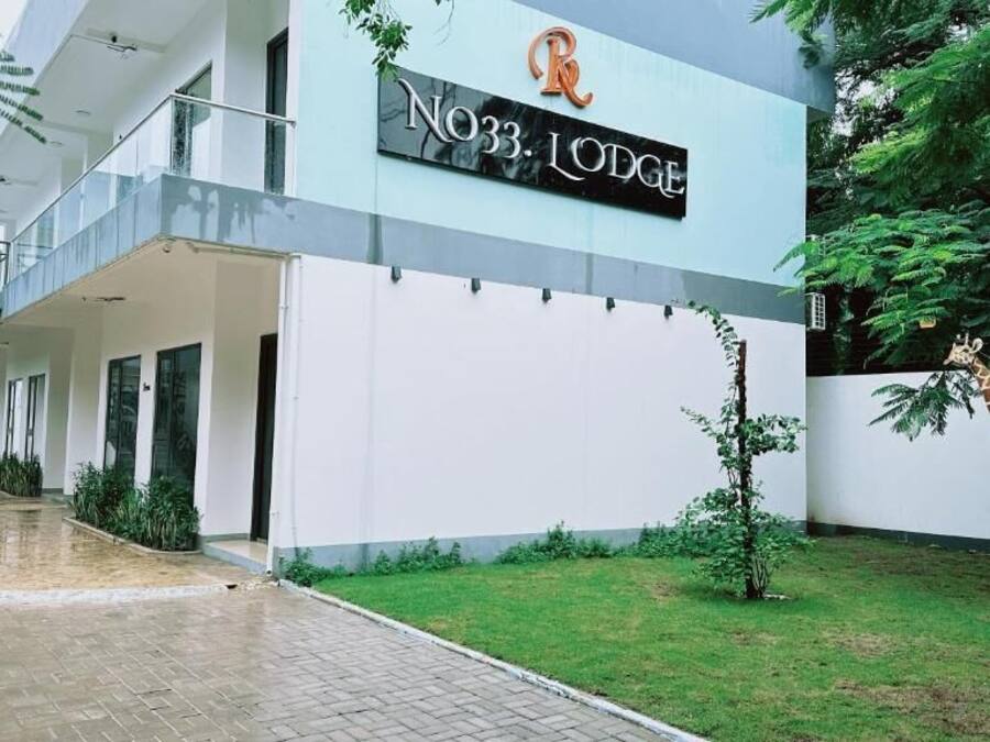 A building with a sign reading "No33. Lodge" and a giraffe statue in the foreground.