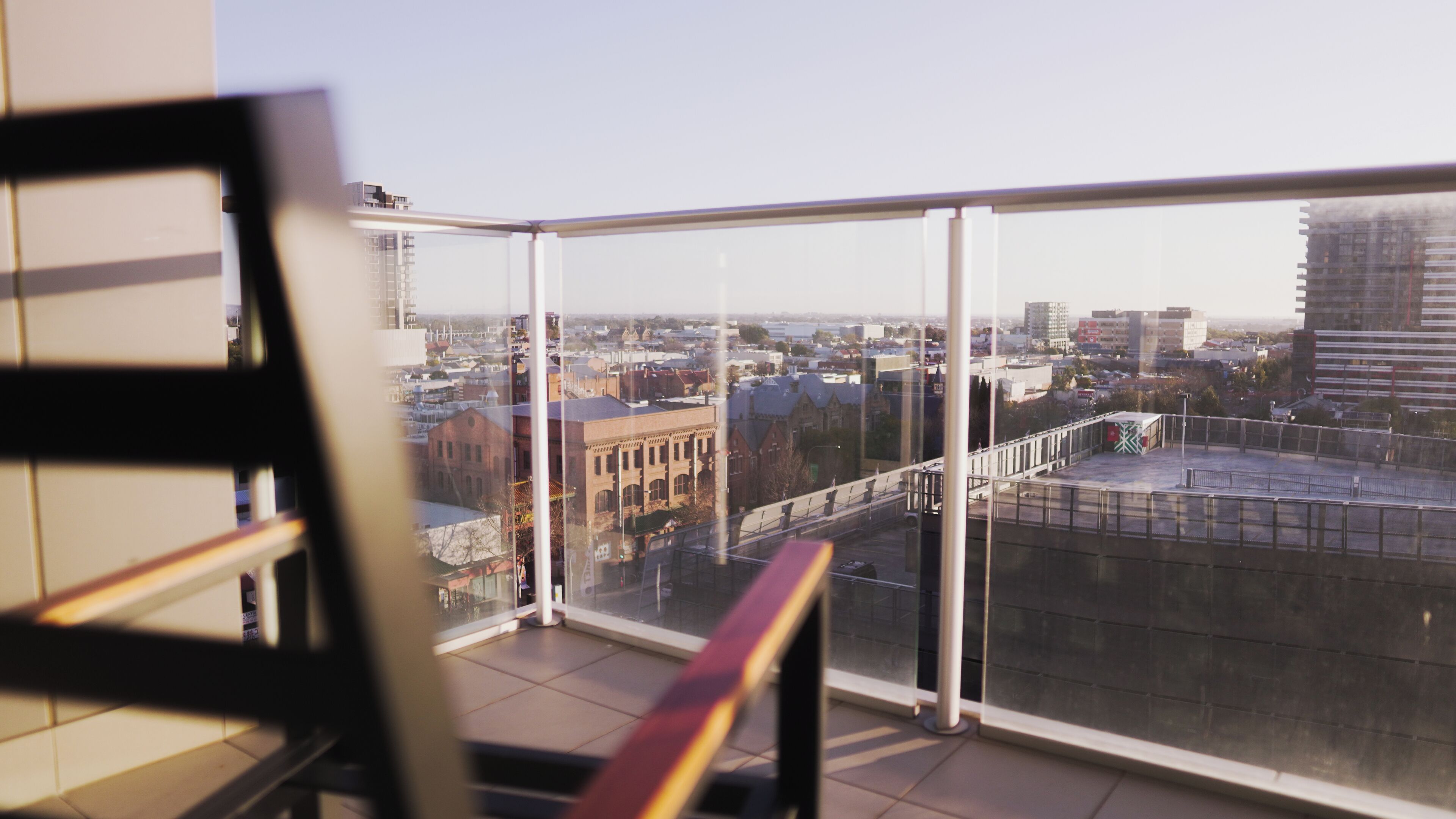 Ein Balkon mit Blick auf eine Stadtlandschaft, einschließlich Gebäude und einer Brücke.