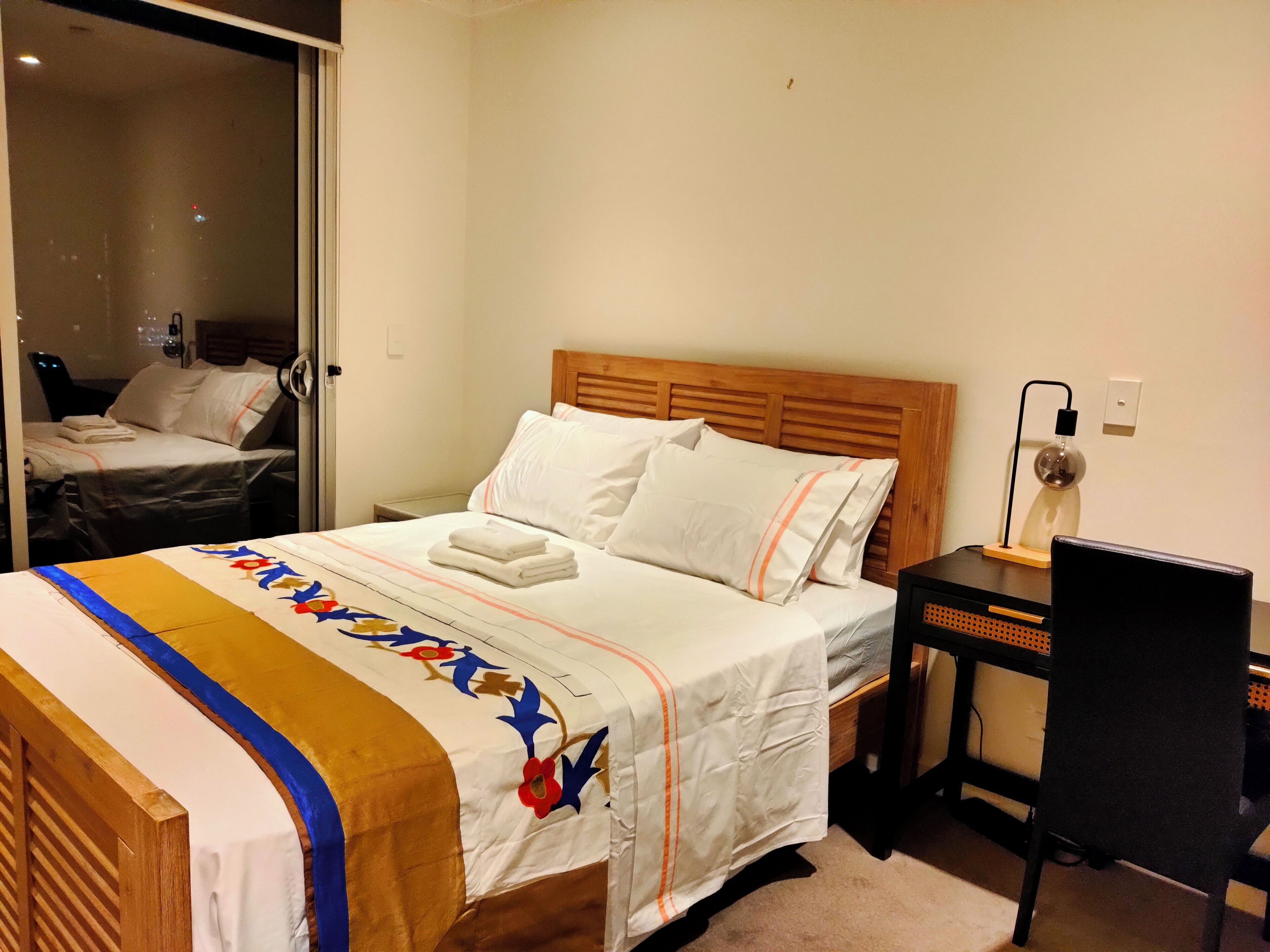 A hotel room with a bed, a desk, and a chair.