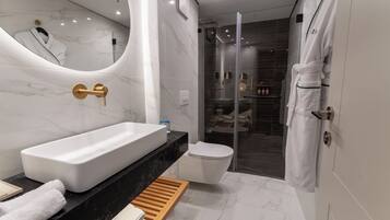 Ein modernes Badezimmer mit einer großen weißen Badewanne, einer separaten Toilette und einer gläsernen Duschkabine.