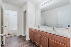 A bathroom with a double sink vanity, a large mirror, and a shower curtain. - Spacious 5BR Dallas Retreat Perfect for Business Travelers Families (Dallas)