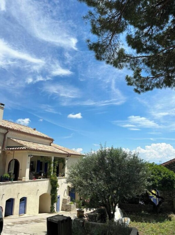 Ein Gebäude im traditionellen mediterranen Stil mit einem Ziegeldach, Rundbögen und einem kleinen Balkon.
