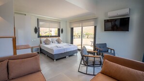 Un dormitorio moderno con cama, sofá y televisión.