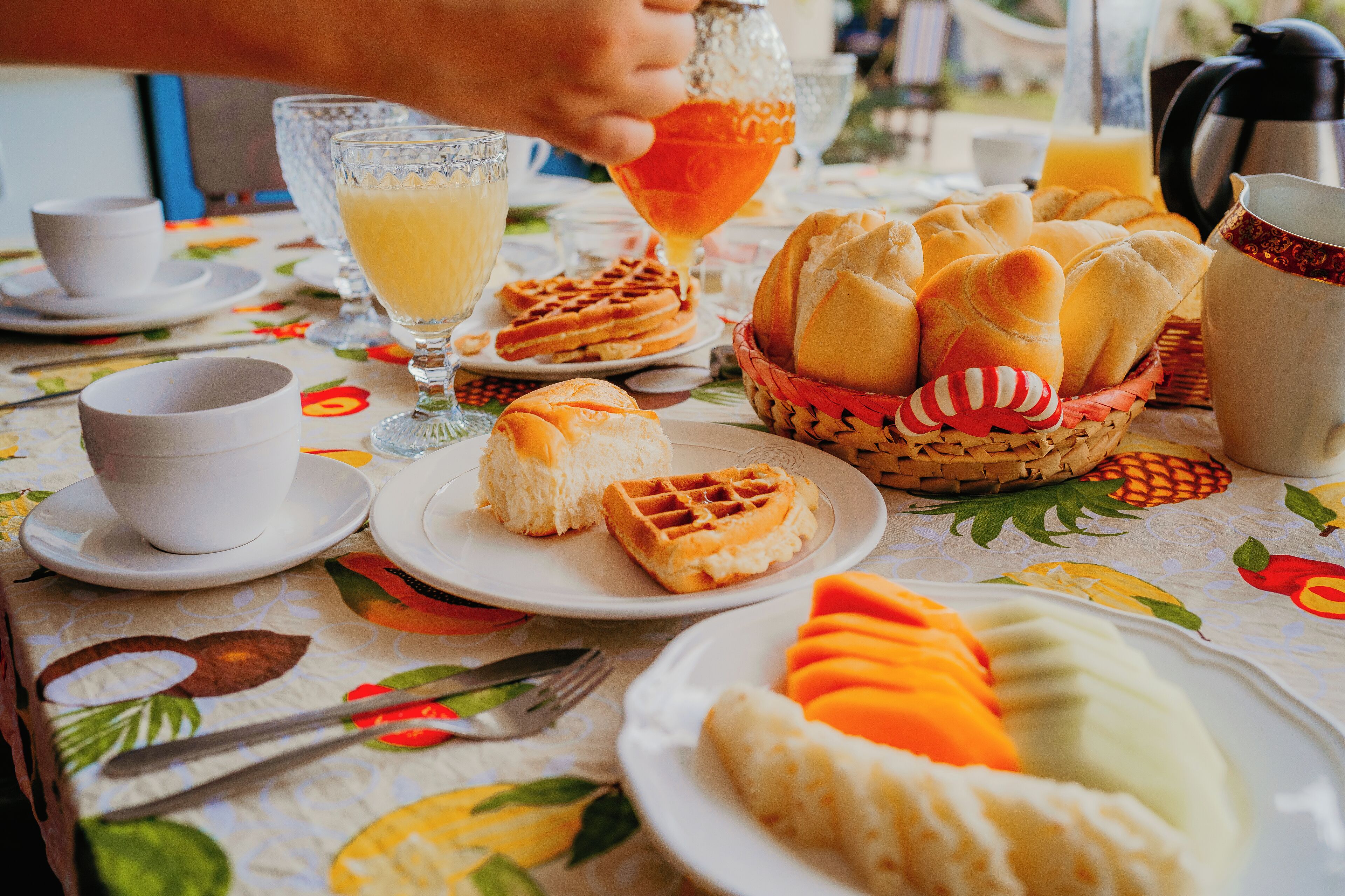 A breakfast table with waffles, croissants, and fruit.