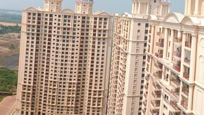 Un immeuble résidentiel de grande hauteur, doté de nombreux étages, de balcons et d’un toit en forme de dôme.