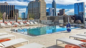 A rooftop pool with lounge chairs and a city skyline in the background. - Wyndham Resort 1BD/1BA Deluxe Suite in fantastic downtown Austin - RACE WEEKEND! (Austin)