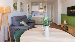 A modern living room with a grey sofa, a wooden coffee table, and a white vase with green plants. - Cozy Studio in Heart of Nueva Andalucía - Pass the Keys (Marbella)