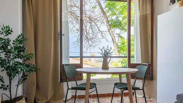 A room with a table and chairs near a window, a potted plant, and a tiled floor. - Cozy Studio in Heart of Nueva Andalucía - Pass the Keys (Marbella)