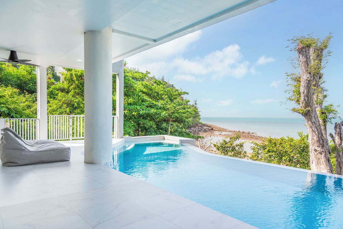 A modern infinity pool with a clear view of the beach and ocean.