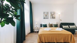 A hotel room with a large bed, a sofa, a small table, and a floor lamp. - Homely Apartments Neu! Wlan Küche Altstadt-sbahn-dd, Elbufer Radweg (Meißen)