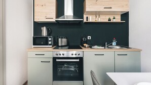 A compact kitchen with a microwave, stove, oven, and wooden cabinets. - Homely Apartments Neu! Wlan Küche Altstadt-sbahn-dd, Elbufer Radweg (Meißen)