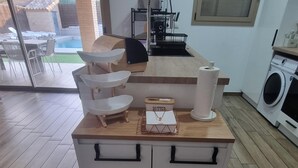 Un îlot de cuisine doté d’un plan de travail, d’un évier et d’un lave-linge encastré.