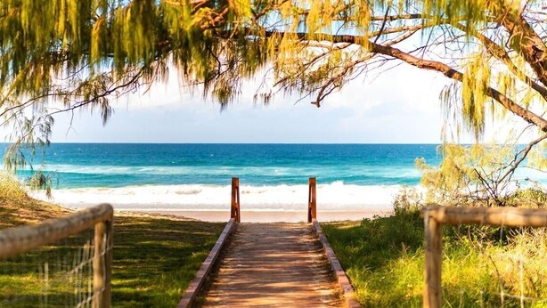 A wooden pathway leading to a beach with a view of the ocean. - Beachfront Escape Broadbeach - 2BD, Pool, Sleeps 7 (Gold Coast)