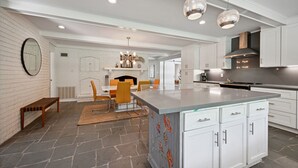 A modern kitchen with white cabinetry, a large island, and pendant lighting. - "Whispering Oaks"  Enjoy this 4-bedroom home with HUGE backyard (Covington)