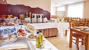 Ein Frühstücksbuffet mit verschiedenen Speisen, einer Kaffeestation und einem Essbereich mit Holztischen und -stühlen.