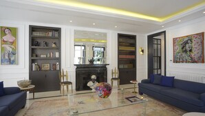 A living room with a fireplace, bookshelves, a sofa, and a coffee table. - L'Hôtel Particulier La Marsa (La Marsa)