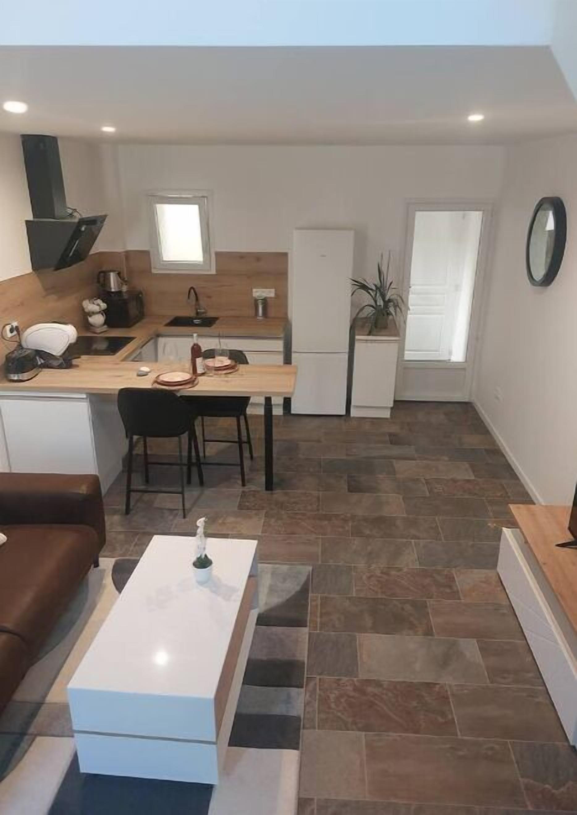 Et moderne køkken med spiseplads, en sofa og et sofabord.
