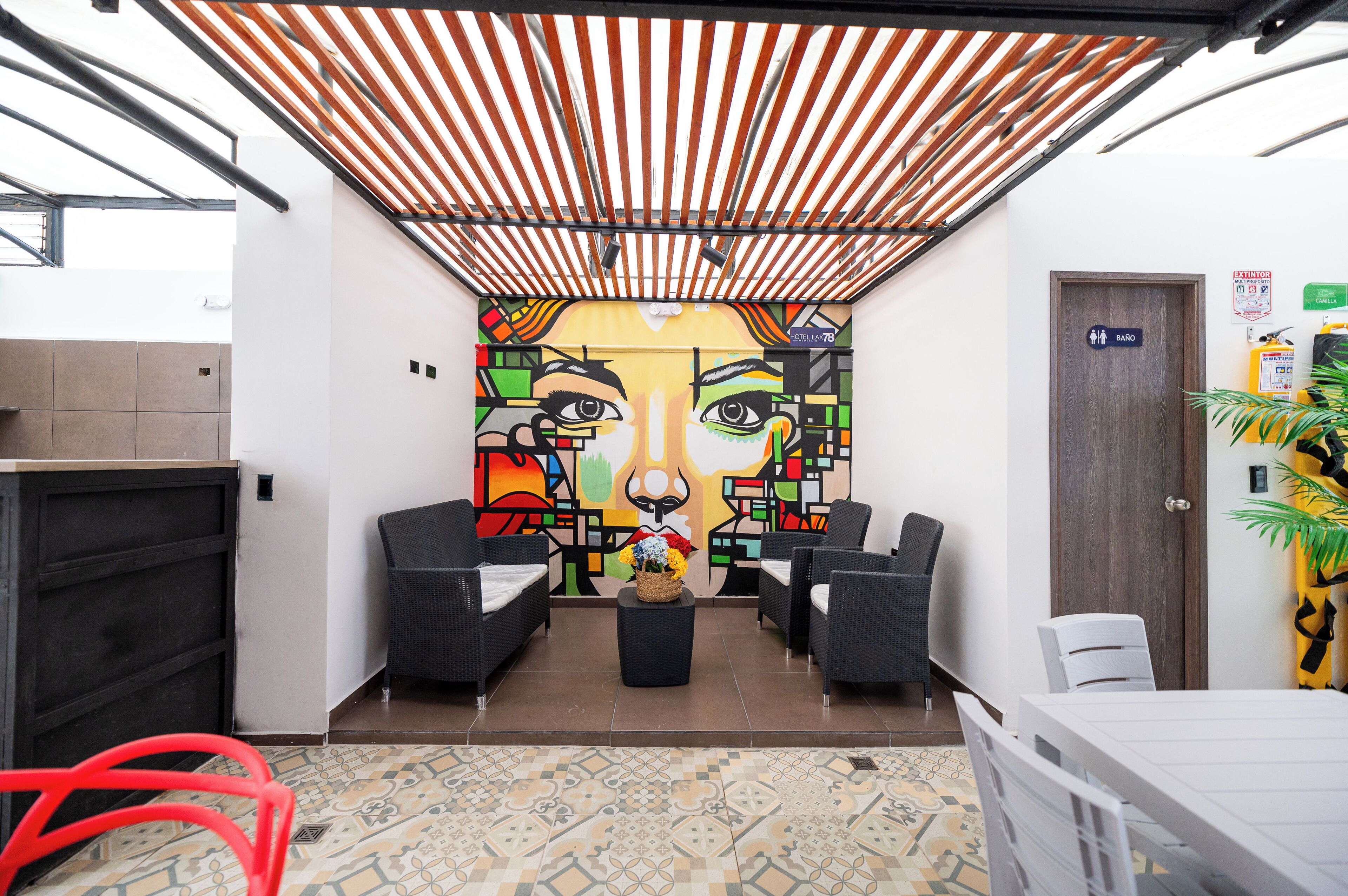 A modern waiting area with a large mural, comfortable seating, and a clean, tiled floor.