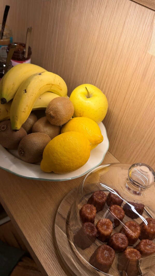 Un piatto di frutta e un bicchiere con dolci su un tavolo di legno.